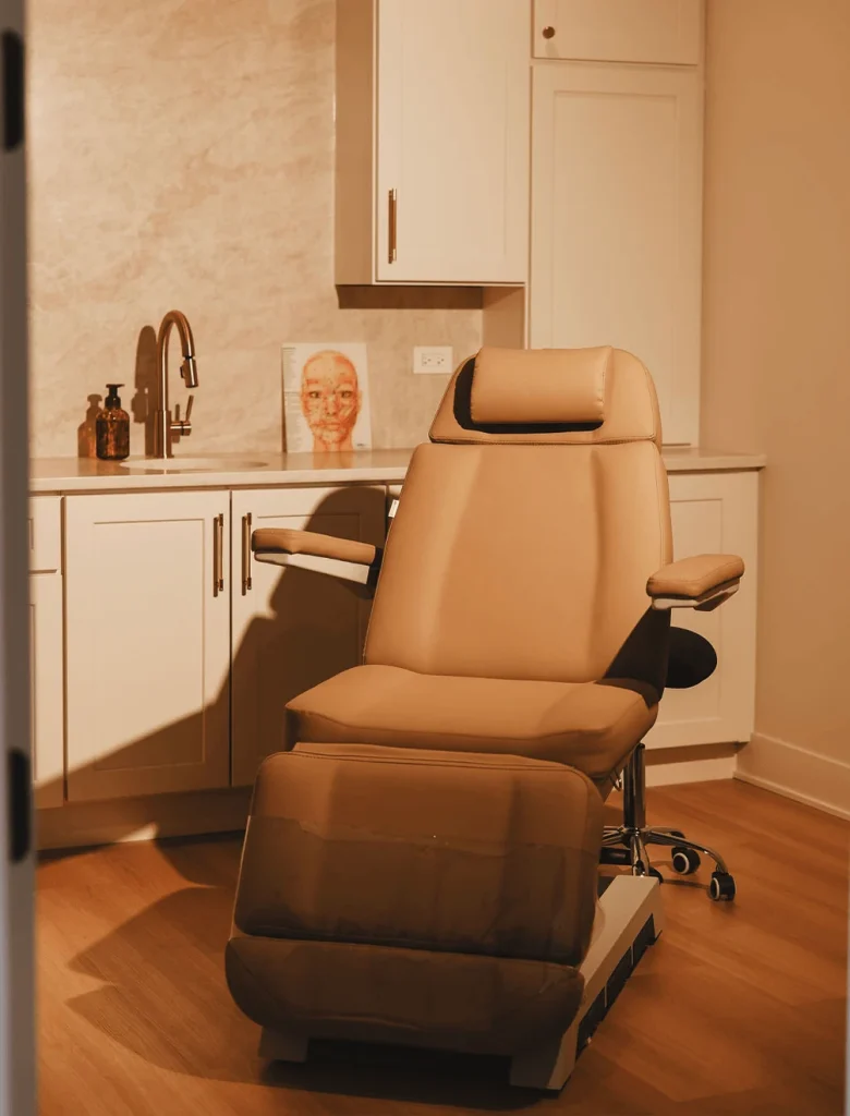 Medical examination chair and sink in a clean, modern clinic room.