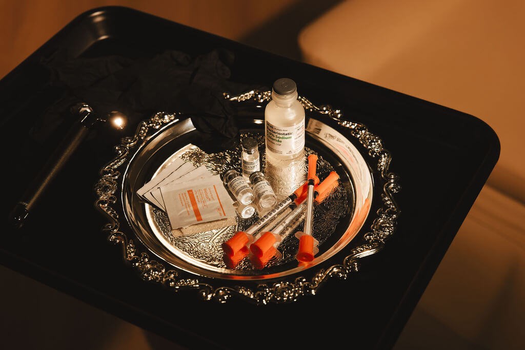 RHA Collection: Syringes, vials, and gloves on a decorative tray.